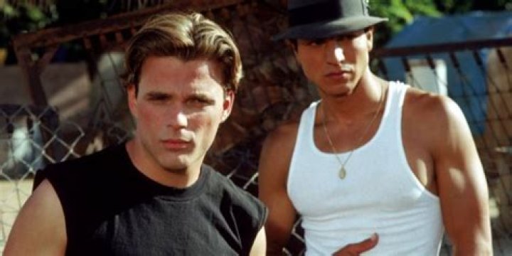 Benjamin Bratt standing in a suit in a warehouse in a still from DMZ