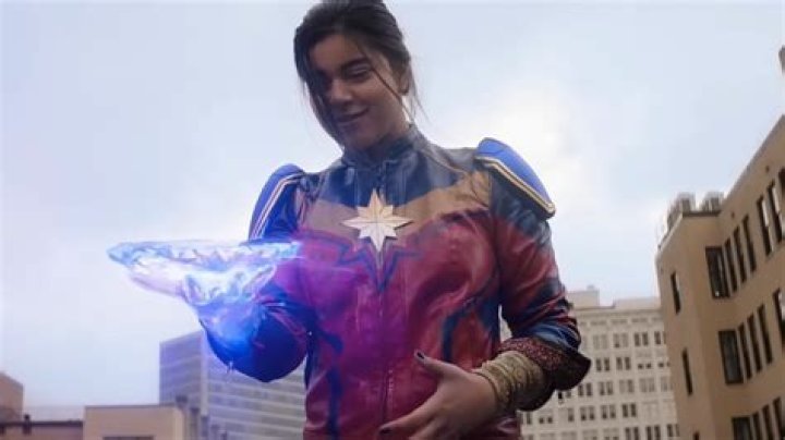 Kamala Khan/Ms. Marvel throws a big stretchy punch made out of faceted hard light, inside a room decorated for a wedding in Ms. Marvel. 